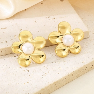 Detail of 18K gold stainless steel flower earrings with a pearl center on silk