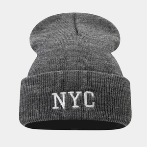 Détail du bonnet en maille grise avec broderie NYC blanche et texture côtelée