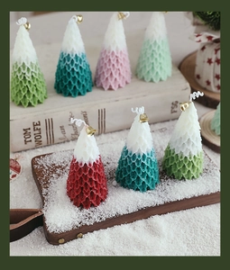 Detailed view of Christmas tree candles with pine textures and festive gold bells on top