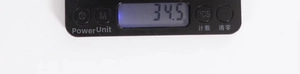 Close-up of portable electronic scale digital display showing 34.5g with function buttons