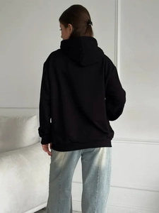 Back view of black oversized hooded sweatshirt featuring minimalist loose fit design
