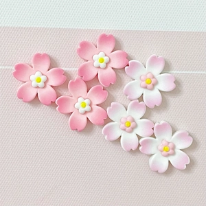 Detail view of resin cherry blossom charms in pink and white for DIY craft accessories