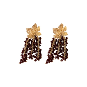 Vintage grapevine earrings with gold leaves and deep red beaded tassels on white background