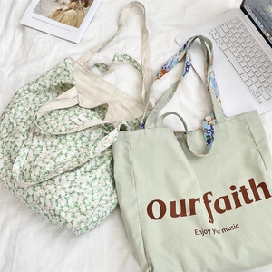 Detail view of floral print and sage green canvas tote bags with laptop and magazine