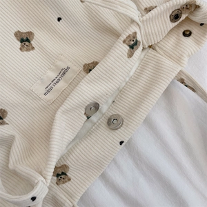 Close-up of corduroy tote texture showing bear print, magnetic snap and brand label