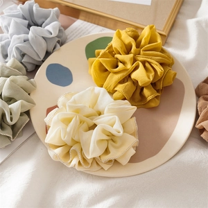 Detail of colorful chiffon scrunchies with elegant pearl edges in a decorative tray