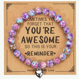 Detail of beaded bracelet with heart charm on a motivational gift card display