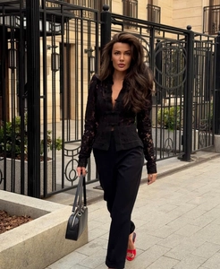 Photo street style d'un mannequin en chemisier en dentelle noire et pantalon taille haute