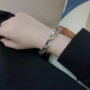 Detail of vintage silver-plated twisted braid bangle worn on wrist for a retro look