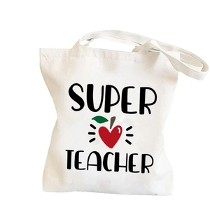 White canvas tote bag featuring Super Teacher text and red heart apple print for school