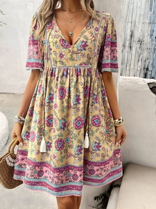 Detail of V-neck printed dress with tassel ties and decorative buttons for summer