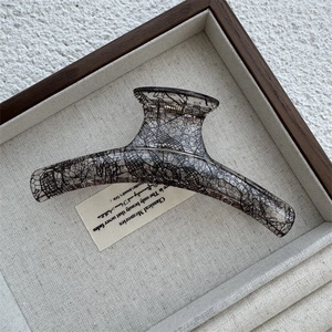 Detail showing high-quality black lace mesh pattern inside translucent amber hair claw clip