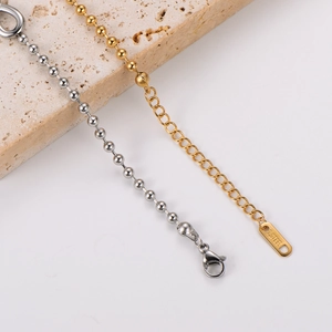 Close-up of gold and silver stainless steel bead chains with infinity symbol details