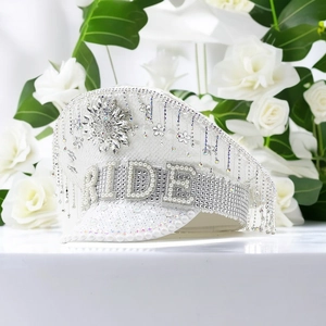 Macro shot of Bride lettering and shimmering rhinestone tassels on a white captain hat
