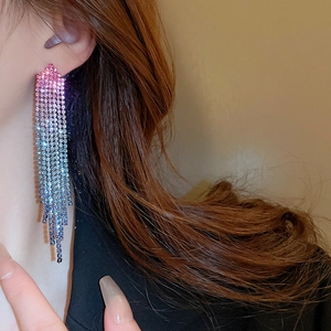 Macro view of gradient rhinestone fringe earrings with pink to blue flowing tassels