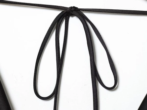Détail d'un nœud en satin noir élégant montrant la texture lisse et l'éclat du tissu
