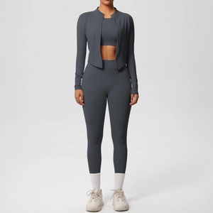 Three-piece dark grey yoga set with zip jacket, crop top, and high-waist leggings