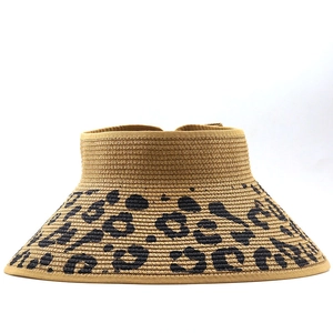 Detail of leopard print straw sun visor with woven texture and black fabric trim