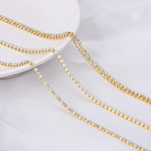 Close-up detail of golden claw chain featuring sparkling AB rhinestones and white pearls