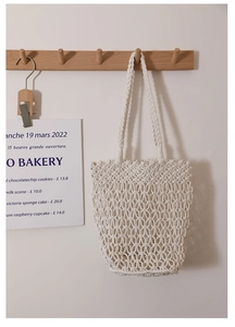 Detailed macro view of the openwork mesh texture on a cream white cotton woven tote bag