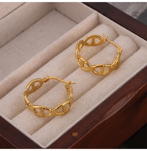 Detailed macro of 18k gold plated hollow oval earrings on premium wooden jewelry box