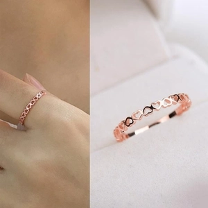 Detailed close-up of rose gold hollow heart-shaped ring band and model hand display