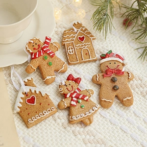 Resin gingerbread man and house Christmas ornaments set on cozy knit background