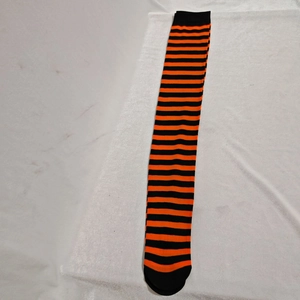 Detailed view of festive orange and black striped over-knee socks for party costumes