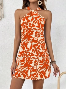 Detail of orange leaf print halter neck dress with ruffled hem and backless design