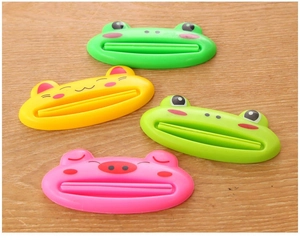 Detail of four colorful cartoon animal tube squeezers on a light wood surface