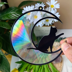 Macro detail of suncatcher featuring black cat on moon with holographic rainbow prism