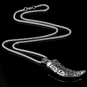 Polished stainless steel crescent horn pendant necklace with intricate relief patterns on black
