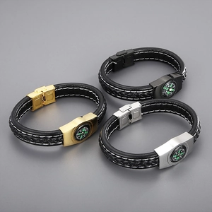 Detail of braided leather survival bracelet with compass in gold, silver, and black finish