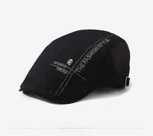 Detail of black beret featuring silver skull badge and embroidered fashion style text
