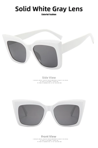 Detail view of white cat-eye sunglasses with thick frames and dark grey lenses