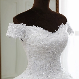 Elegant off-shoulder wedding dress with intricate lace embroidery and sequined beads