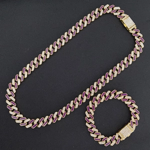 Close-up of golden Cuban chain set with purple accents and pavé diamond box clasps