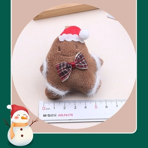 Close-up of plush gingerbread man with red Santa hat and festive plaid bowtie