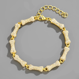 Detailed view of golden bone-link bracelet with sparkling rhinestones and lobster clasp