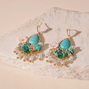 Detail of vintage flower drop earrings with turquoise stones and pearl tassels