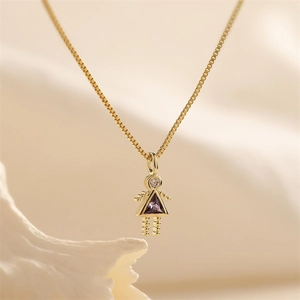 Macro detail of gold-plated girl pendant with purple and clear zircon stones on box chain