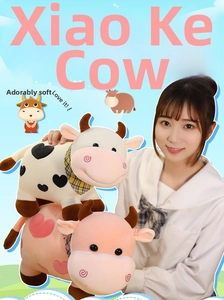 Peluche de vaca lindo en rosa y negro con corazones mostrado con modelo como referencia