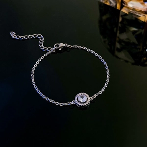 Detail of silver chain bracelet with round zircon pendant and lobster clasp closure