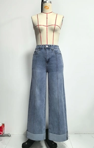 Detail van high waist jeans met wijde pijpen in lichtblauw met naad en omgeslagen zoom