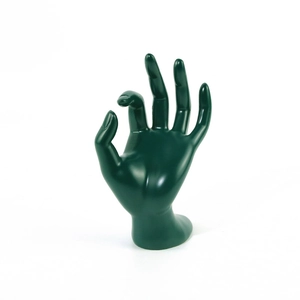 Macro shot of dark green resin hand-shaped display stand for rings and bracelets
