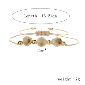 Detail of bohemian shell bead bracelet with adjustable woven cord and 10mm gold beads