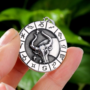 Macro shot of silver Taurus zodiac pendant with embossed bull head and vintage oxidation