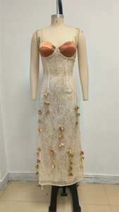 Détail d'une robe de soirée en dentelle beige avec feuilles dorées et paillettes