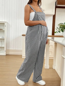 Side view of checkered maternity jumpsuit with adjustable straps and loose leg fit
