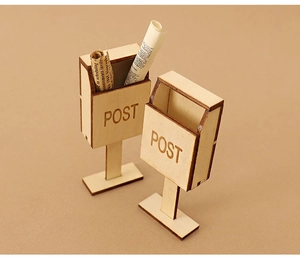 Macro detail of two miniature wooden dollhouse mailboxes with engraved POST lettering
